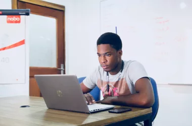 A black guy operating laptop